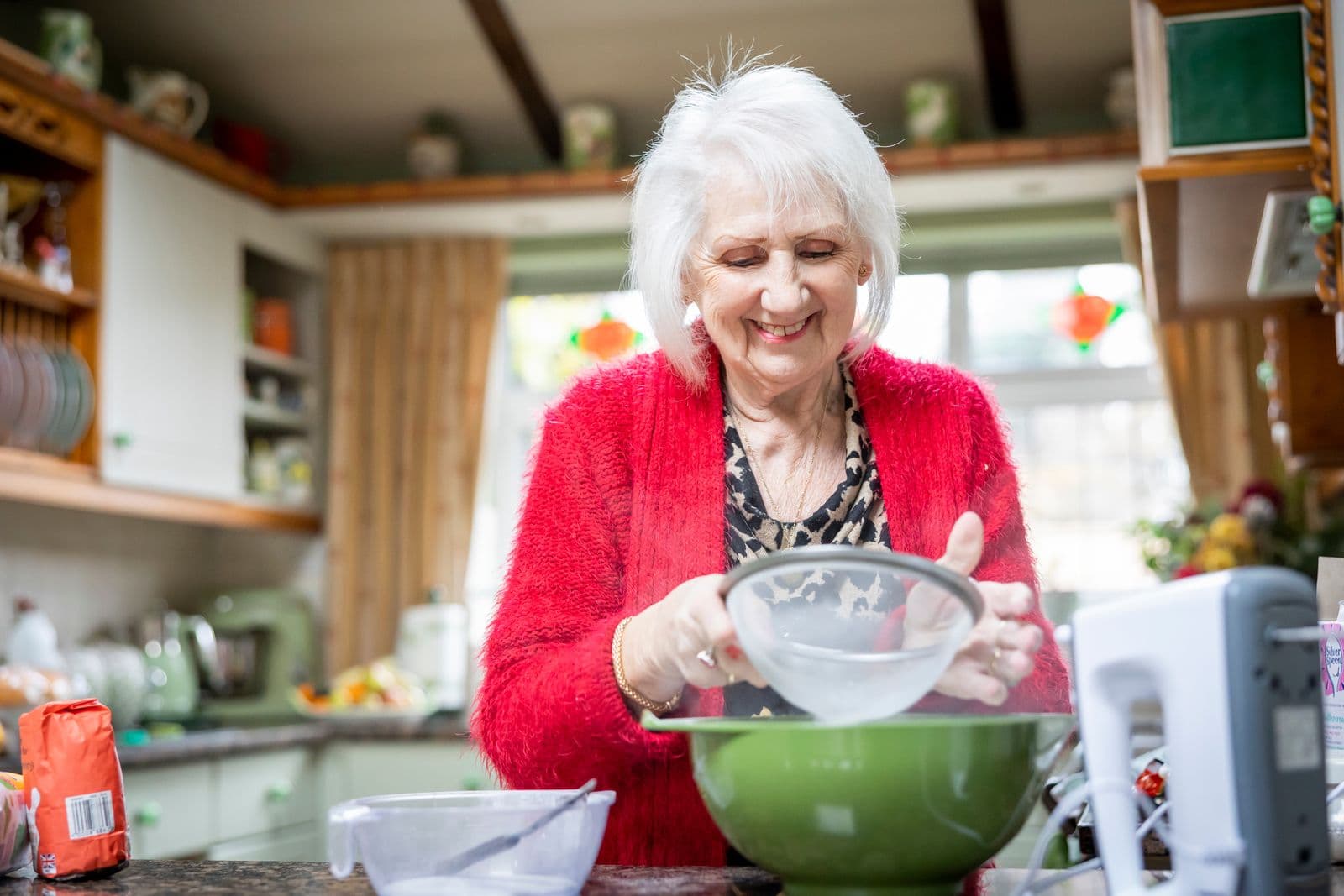 A woman in her seventies baking in her kitchen