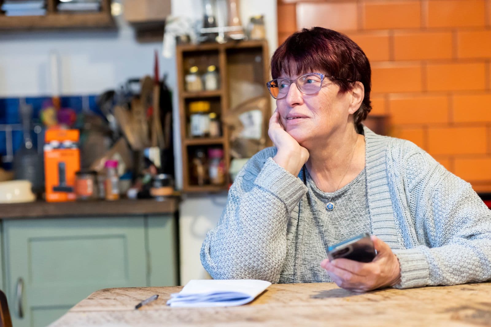 A woman in her seventies at her kitchen table